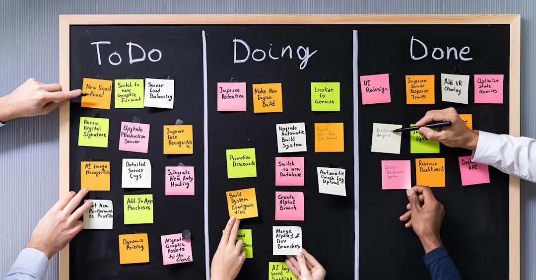 Händer som flyttar färgglada post-it-lappar på en svart planeringstavla.